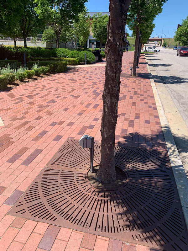 ADA compliant Sunray tree grates installed in brick sidewalk outside of Guthrie Green  in Tulsa, Oklahoma