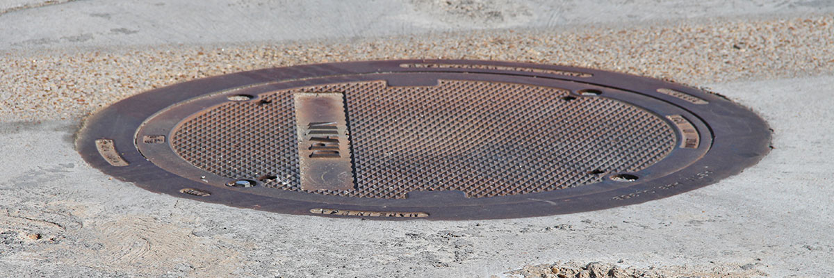 Bolted manhole frame and cover installed in concrete